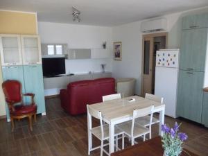 eine Küche und ein Wohnzimmer mit einem Tisch und einem roten Sofa in der Unterkunft casa vacanze via della seta in Lauria Inferiore