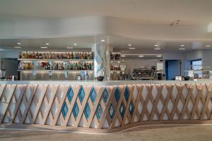 a bar in a restaurant with a counter at Hotel Portoconte in Porto Conte