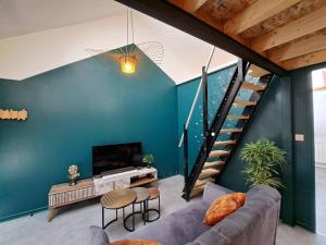 a living room with a couch and a staircase at Cardiff - Appartement Centré in Reims