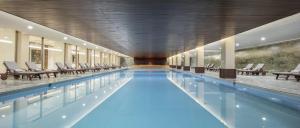 a large swimming pool with chairs in a building at MEDWORLD COSMOS Health & Rehabilitation Center in Antalya