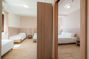 a hotel room with two beds and a mirror at Hotel Portoconte in Porto Conte