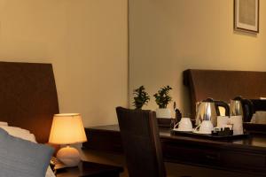 ein Hotelzimmer mit einem Schreibtisch und einem Tisch mit einer Lampe in der Unterkunft The Waterfront in Negombo