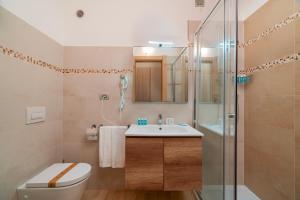 a bathroom with a toilet and a sink and a shower at Hotel Portoconte in Porto Conte