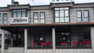 a building with red tables and chairs on the porch at Hotel Akelarre in Santiago de Compostela