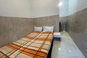Ένα ή περισσότερα κρεβάτια σε δωμάτιο στο SPOT ON 93149 Karman's Sari 1 Homestay Syariah