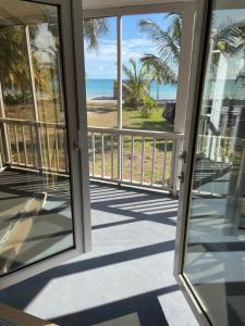 a view of the beach from the balcony of a house at Winfield Manor home in Governorʼs Harbour