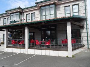 a restaurant with red tables and chairs on a balcony at Hotel Akelarre in Santiago de Compostela