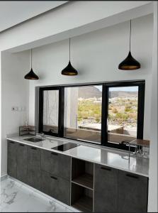 a kitchen with a sink and a large window at استراحة رافلز in Sayq