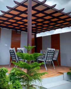 un patio con sillas y una mesa bajo una pérgola en استراحة رافلز, en Sayq