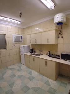 a kitchen with a sink and a refrigerator at وحدة الأنس 11 in Al Madinah