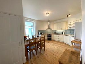 a kitchen with a table and chairs and a dining room at Smugglers View in Niton