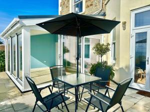 a table and chairs with an umbrella on a patio at Smugglers View in Niton