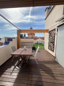 patio con mesa de madera y sillas en el balcón en Iberflat Fabiola en Sevilla