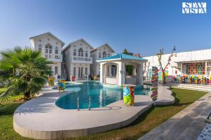 une grande maison avec une piscine en face de celle-ci dans l'établissement StayVista's Udaan Manor with Outdoor Pool, Jacuzzi & Lush Lawn with Gazebo & Bar, à Chandigarh