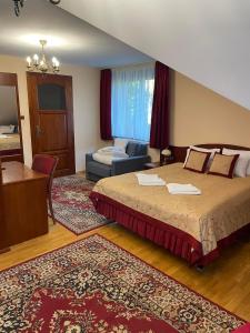 um quarto com uma cama e uma sala de estar em Pensjonat Szach em Krynica-Zdrój