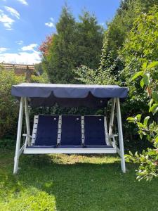 a bench with a table and chairs in the grass at Hybel med bad in Egersund