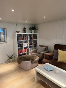 a living room with a couch and a book shelf at Hybel med bad in Egersund