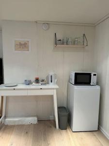 a small kitchen with a microwave and a refrigerator at Hybel med bad in Egersund