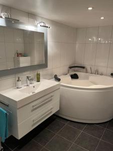 a bathroom with two sinks and a tub and a mirror at Hybel med bad in Egersund