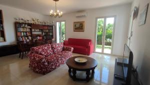 a living room with a red couch and a table at Villa Mariella in Taormina