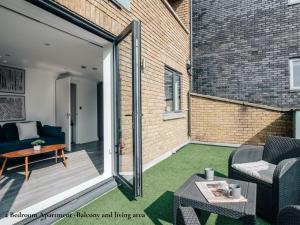 a patio with a couch and a table at Lux Bermondsey Apartments Near Tower Bridge in London