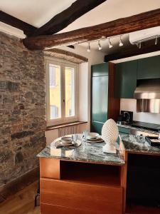a kitchen with a counter and a stone wall at Kiko's Lodge - Historical apartment in Como in Como