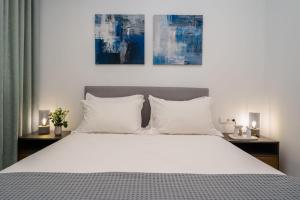 a bedroom with a large bed with white pillows at Infinity View Apartment in Naxos Chora