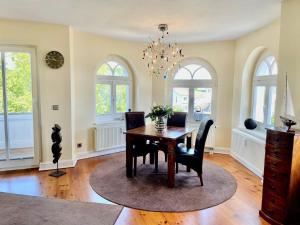 ein Esszimmer mit Tisch und Stühlen und Fenstern in der Unterkunft Villa Metropol - WE 14 in Strandnähe und zentrumsnah in Binz + 25 Fotos
