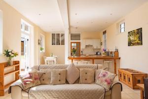 a living room with a couch and a kitchen at The Bothy - Charming home on a working farm in Faversham