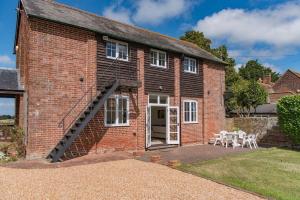 a brick house with a staircase leading up to it at The Bothy - Charming home on a working farm in Faversham