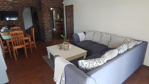 a living room with a blue couch and a table at THE BOAT HOUSE, 53 Nkwazi Drive in Zinkwazi Beach +7 photos