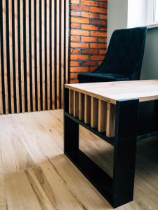 a table and a chair in a room with a brick wall at The View in Iława