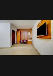 a living room with a flat screen tv on a wall at HILL BIRD HERITAGE HOME Stay in Ooty