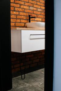 a bathroom with a sink and a brick wall at The View in Iława