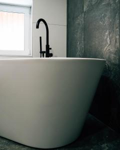 a bath tub with a faucet in a bathroom at The View in Iława