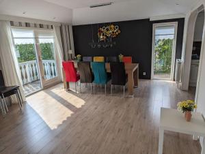 a dining room with a table and colorful chairs at Chalet Anloo, van harte welkom. in Anloo