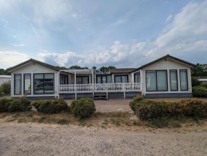 uma grande casa branca com muitas janelas em Chalet Anloo, van harte welkom. em Anloo