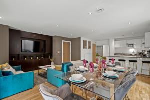 sala de estar con mesa de cristal y sillas azules en Beautiful Duplex - Sleeps 10, en Londres