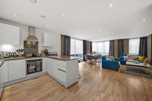 cocina y sala de estar con sofá y mesa en Beautiful Duplex - Sleeps 10, en Londres