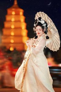 Banma Family All-Suite B&B في شيان: امرأة ترتدي ثوب أبيض مع مظلة