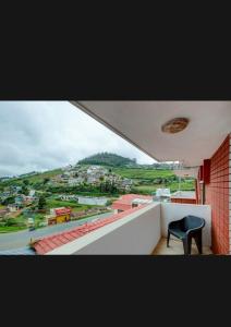 a black chair sitting on the ledge of a balcony at HILL BIRD HERITAGE HOME Stay in Ooty