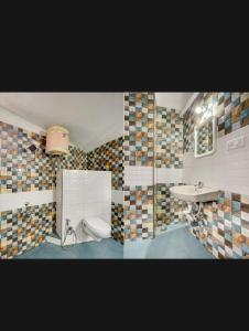 two pictures of a bathroom with a toilet and a sink at HILL BIRD HERITAGE HOME Stay in Ooty