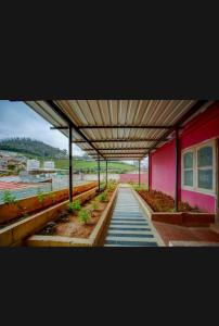 a train station with a red building and a walkway at HILL BIRD HERITAGE HOME Stay in Ooty