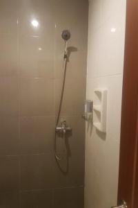 La salle de bains est pourvue d'une cabine de douche avec un pommeau de douche. dans l'établissement OYO 93145 Pondok Alam Syariah, à Jakarta