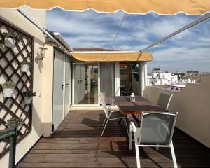 eine Terrasse mit einem Tisch und Stühlen auf dem Balkon in der Unterkunft Iberflat Fabiola in Sevilla