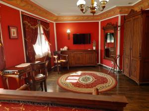 a living room with red walls and a table and chairs at Family Hotel at Renaissance Square in Plovdiv