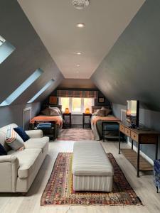 a attic living room with two beds and a couch at The Hay Loft in Warnham