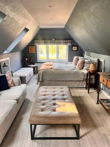 una camera con due letti e un divano di The Hay Loft a Warnham