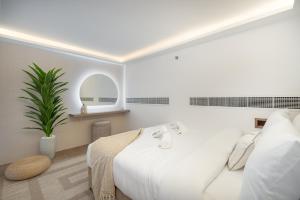 a white bedroom with a bed and a plant at Unique Loft design in JVC with relaxing in Dubai