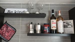 une étagère avec des bouteilles de vin et des verres sur un mur dans l'établissement Suite in città, à Naples